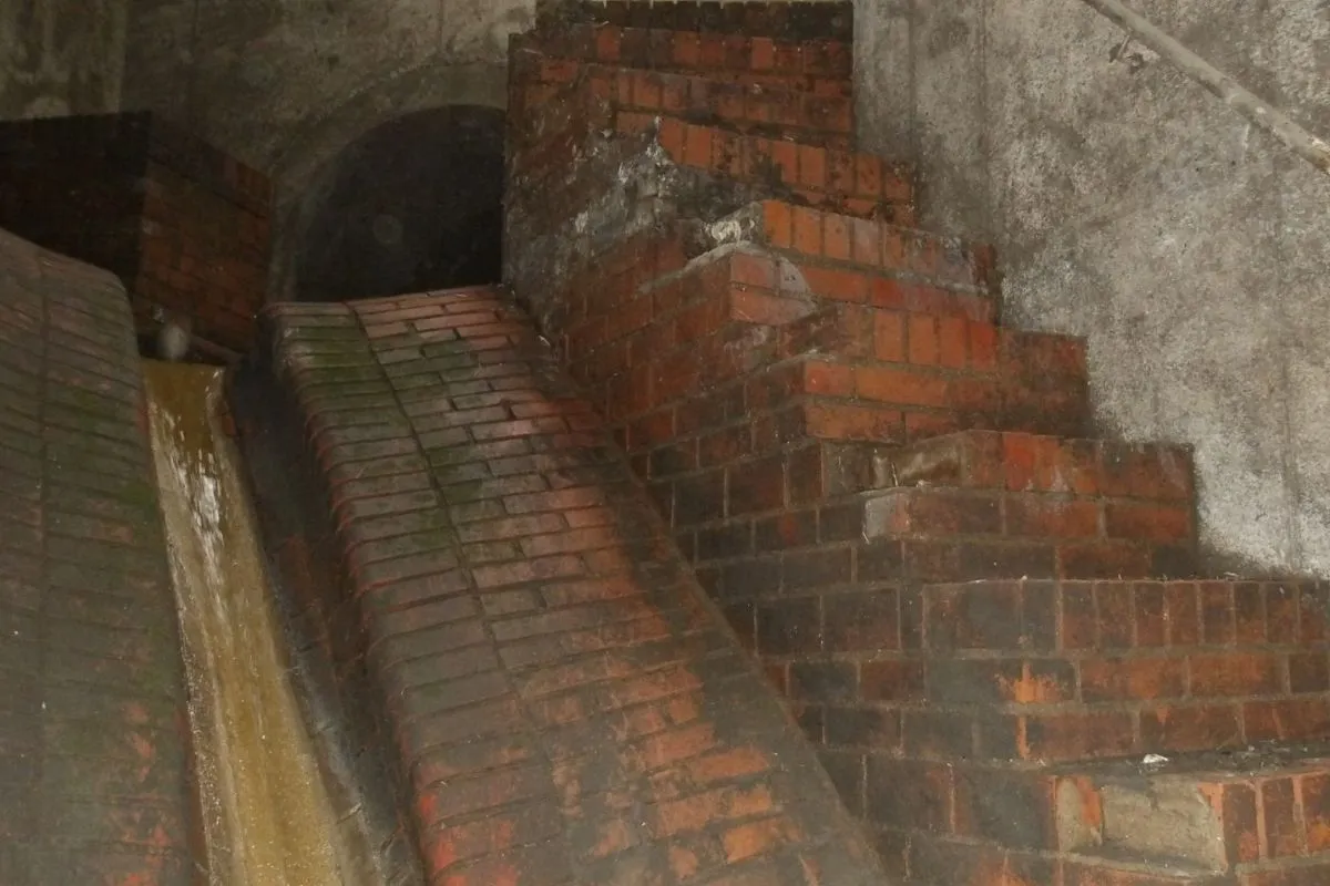 Gemauertes Ziegelgerinne mit Ablagerungen und geschädigten Oberflächen im Sonderbauwerk